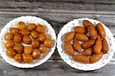 Assorted middle eastern desserts of Zalabia a type of middle eastern fried dough similar to that of a doughnut, and Egyptian Zainab fingers or glazed anise fingers, flour with semolina in honey syrup clipart