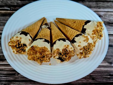 Karamelli Bisküvi Dondurması, Gofret bisküvilerinde eriyen soğuk dondurma, yaz tatili konsepti, çikolata parçalı dondurma küvisi, fındık, bisküvi, çıtır çıtır karamel.