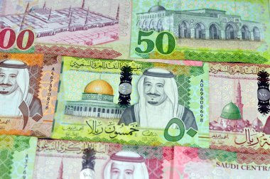 Background of Saudi Arabia money banknotes bill of different values, 100, 50, 10 and 5 riyals of King Salman Bin AbdulAziz Al Saud era, Saudi money exchange rate and economy status, pile of riyals clipart