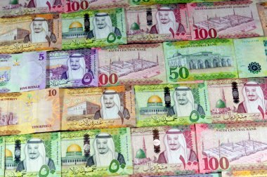 Background of Saudi Arabia money banknotes bill of different values, 100, 50, 10 and 5 riyals of King Salman Bin AbdulAziz Al Saud era, Saudi money exchange rate and economy status, pile of riyals clipart