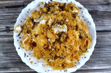 Mısır 'daki tatlı Koshary tarifinin üstüne sütlü puding, krem şanti, kızarmış Konafa ve filo ile birlikte diğer tatlar ve dolgulardan yapılmış çikolata ezmesi sosu.