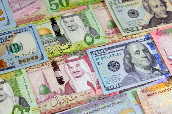 stock image American USD money dollars bills, Saudi Arabia money banknotes bill of different values, 100, 50, 10 and 5 riyals of King Salman Bin AbdulAziz Al Saud era, Saudi money exchange rate and economy status