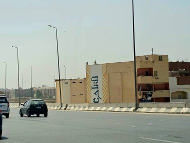 Giza, Mısır, 17 Mayıs 2024: Büyük Giza Mısır Müzesi yolundaki binaların dış görsel iyileştirmeleri, inşaat halindeki çevre yolundaki binaları boyamak ve geliştirmek