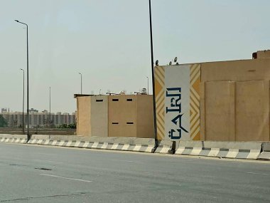Giza, Mısır, 17 Mayıs 2024: Büyük Giza Mısır Müzesi yolundaki binaların dış görsel iyileştirmeleri, inşaat halindeki çevre yolundaki binaları boyamak ve geliştirmek