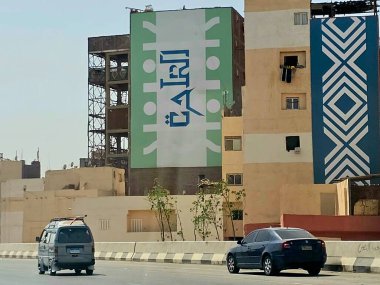 Giza, Mısır, 17 Mayıs 2024: Büyük Giza Mısır Müzesi yolundaki binaların dış görsel iyileştirmeleri, inşaat halindeki çevre yolundaki binaları boyamak ve geliştirmek