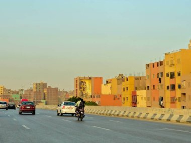 Giza, Mısır, 17 Mayıs 2024: Büyük Giza Mısır Müzesi yolundaki binaların dış görsel iyileştirmeleri, inşaat halindeki çevre yolundaki binaları boyamak ve geliştirmek