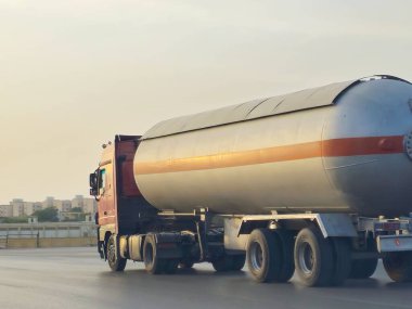 Kahire, Mısır, 17 Mayıs 2024: Yakıt petrol ürünleriyle dolu bir konteynır tankı olan büyük bir kamyon, otoyolda bir konteynır ve ürünleri benzin istasyonuna teslim eden bir kamyon