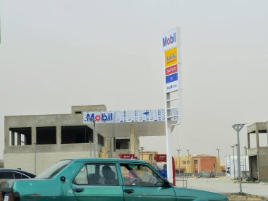 Kahire, Mısır, 10 Mayıs 2024: Mobil doğalgaz, inşaat halindeki petrol istasyonu, Mobil ExxonMobil şirketinin küresel petrol endüstrisi, Mobil1 hizmet merkezi ve içinde kaçak olarak çalışan benzin istasyonu