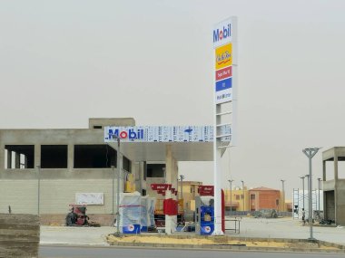 Kahire, Mısır, 10 Mayıs 2024: Mobil doğalgaz, inşaat halindeki petrol istasyonu, Mobil ExxonMobil şirketinin küresel petrol endüstrisi, Mobil1 hizmet merkezi ve içinde kaçak olarak çalışan benzin istasyonu