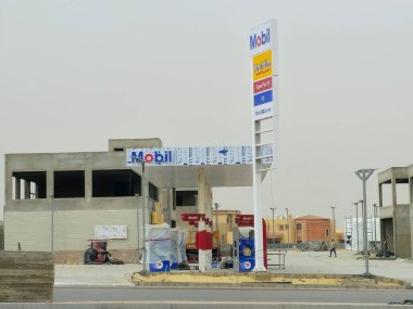Kahire, Mısır, 10 Mayıs 2024: Mobil doğalgaz, inşaat halindeki petrol istasyonu, Mobil ExxonMobil şirketinin küresel petrol endüstrisi, Mobil1 hizmet merkezi ve içinde kaçak olarak çalışan benzin istasyonu