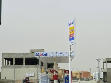 Kahire, Mısır, 10 Mayıs 2024: Mobil doğalgaz, inşaat halindeki petrol istasyonu, Mobil ExxonMobil şirketinin küresel petrol endüstrisi, Mobil1 hizmet merkezi ve içinde kaçak olarak çalışan benzin istasyonu