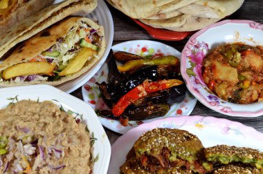 Mashed fava beans done the Alexandrian way of Egypt, mixture of potatoes fried fingers, fried aubergine, Egyptian falafel green burger, eggs, tahini, green salad in sandwiches and Moussaka plate