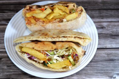 mixture of potatoes fried fingers, mashed fava beans, fried aubergine, Egyptian falafel green burger, eggs, tahini, potatoes and green salad in flatbread, traditional Egyptian popular breakfast