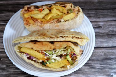 mixture of potatoes fried fingers, mashed fava beans, fried aubergine, Egyptian falafel green burger, eggs, tahini, potatoes and green salad in flatbread, traditional Egyptian popular breakfast