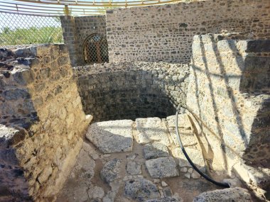 Al Ghars well, a historical site linked to prophet Muhammed peace be upon him, lined with basalt stones, surrounded by building foundations, near Quba mosque, Prophet was said to have drunk from it clipart