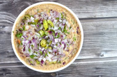 Mashed fava beans mixed with oil, sesame tahini, cumin, spices, slices of chili pepper and onion, traditional popular Egyptian fava bean done the Alexandrian way of Alexandria city of Egypt