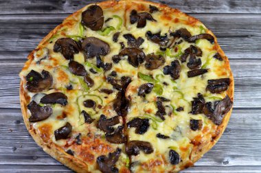 Siyah mantar dilimli mantar pizzası, zeytin, sebze, mozarella peyniri, zeytin yağı ve taze otlar, yüksek kenarlı yuvarlak, fırında pişirilmiş, seçici odaklı
