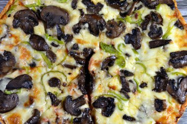 Siyah mantar dilimli mantar pizzası, zeytin, sebze, mozarella peyniri, zeytin yağı ve taze otlar, yüksek kenarlı yuvarlak, fırında pişirilmiş, seçici odaklı
