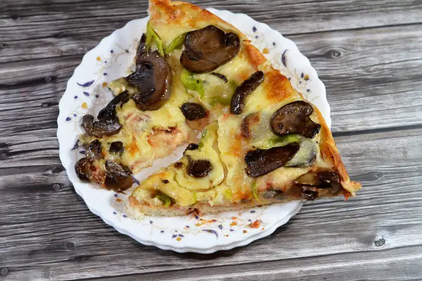 Siyah mantar dilimli mantar pizzası, zeytin, sebze, mozarella peyniri, zeytin yağı ve taze otlar, yüksek kenarlı yuvarlak, fırında pişirilmiş, seçici odaklı