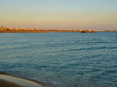 Yazın gün ışığında Mısır 'ın güney Sina' sında kızıl deniz, deniz dalgalı insanların olmadığı doğal panoramik boş sahil, seçici bir odak noktası olan sahile vurur.