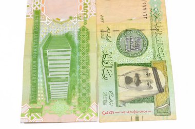1 SAR 1 Suudi Arabistan riyal banknotunda Kral Abdullah ve Suudi Arabistan Para Ajansı 'nın genel merkez binası ve Suudi Arabistan' ın eski model eski Suudi parası silahları yer alıyor.