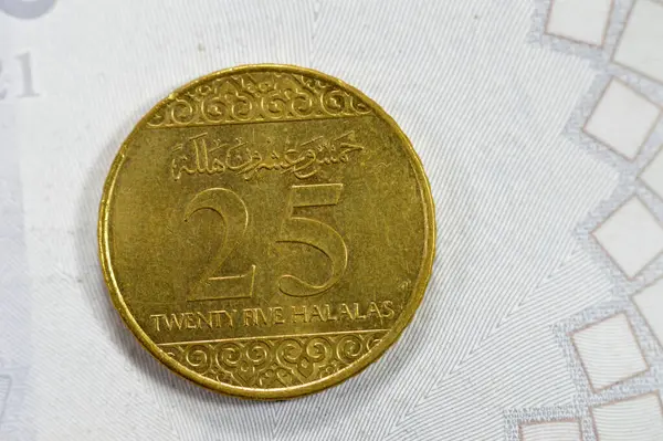 stock image A quarter of SAR Saudi Arabian riyal coin 25 Halalas, features Coat Of Arms Two crossed swords and Palm Tree, Name of King Salman Bin AbdulAziz on the obverse, Trefoil Floral Ornamentation on reverse