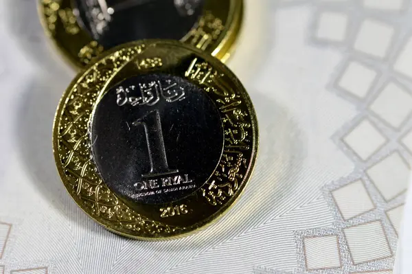 stock image One SAR coin Saudi Arabian Riyal features King Salman Bin Abdul Aziz Al Saud on the obverse side, and Multiple Coat of Arms within the Floral Ornamentation on obverse and reverse sides