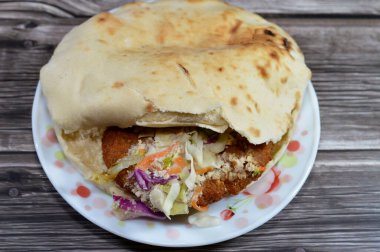 Doldurulmuş Falafel sandviçi, çok popüler ve geleneksel bir Mısır yemeği, gevrek ve kıtır doğranmış domatesli, salatalıklı, soğanlı, tahinili, gevrek sıcak falafel toplarıyla doldurulmuş bir Shami Suriye pide ekmeği.