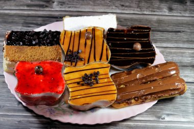 Kremayla doldurulmuş çeşitli Gateau çikolatalı ekler, klasik pudra şekeri Mille feille pastası, bisküvi gateau ve karamel, çikolata ve krem şantili çilekli kekler.