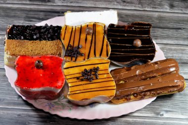 Kremayla doldurulmuş çeşitli Gateau çikolatalı ekler, klasik pudra şekeri Mille feille pastası, bisküvi gateau ve karamel, çikolata ve krem şantili çilekli kekler.