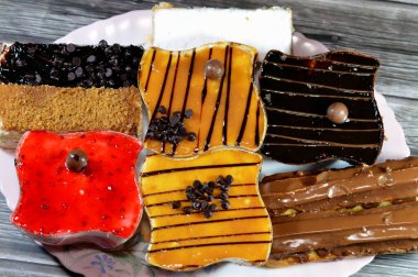 Kremayla doldurulmuş çeşitli Gateau çikolatalı ekler, klasik pudra şekeri Mille feille pastası, bisküvi gateau ve karamel, çikolata ve krem şantili çilekli kekler.