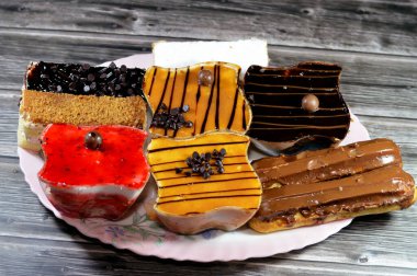 Kremayla doldurulmuş çeşitli Gateau çikolatalı ekler, klasik pudra şekeri Mille feille pastası, bisküvi gateau ve karamel, çikolata ve krem şantili çilekli kekler.