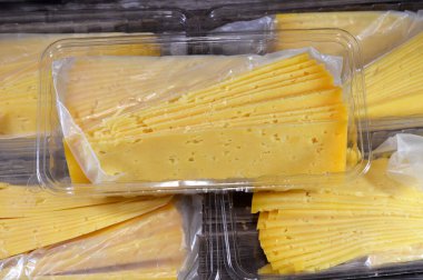 Slices of Egyptian Rumi cheese, also called gebna romiya or gebna turkiya, Roumi, Romi also Romy, middle Eastern parmesan hard cheese, has a pungent smell, and different degrees of saltiness clipart