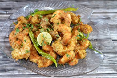 Fried shrimps with parsley, fried green chili pepper and lemon, crunchy fried peeled shrimps seasoned with salt, pepper and spices, a shrimp is a crustacean form of shellfish belongs to the Caridea clipart