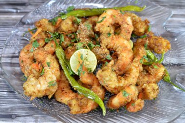 Fried shrimps with parsley, fried green chili pepper and lemon, crunchy fried peeled shrimps seasoned with salt, pepper and spices, a shrimp is a crustacean form of shellfish belongs to the Caridea clipart