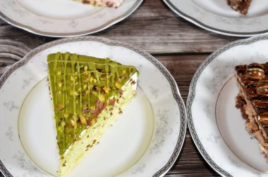 Süngerimsi kek parçaları çeşitli malzemelerle doldurulmuş krema, çikolata ezmesi, çikolata parçaları ve top çikolatalar, bisküvi sosu ve yapıştırıcı, karamel, şam fıstığı parçaları ve krema, ceviz