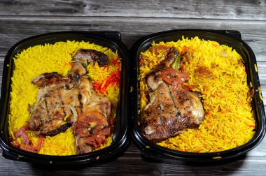 Arabian cuisine of charcoal grilled barbecued chicken with colorful Basmati rice, recipe, moist and juicy barbecued bbq chicken quarters with long Basmati rice isolated on wooden background clipart