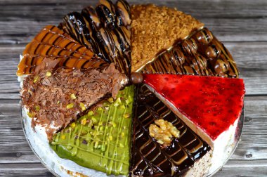 Süngerimsi kek parçaları çeşitli malzemelerle doldurulmuş krema, çikolata ezmesi, çikolata parçaları ve top çikolatalar, bisküvi sosu ve yapıştırıcı, karamel, şam fıstığı parçaları ve krema, ceviz