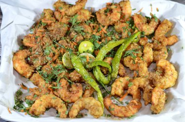 Fried shrimps with parsley, fried green chili pepper and lemon, crunchy fried peeled shrimps seasoned with salt, pepper and spices, a shrimp is a crustacean form of shellfish belongs to the Caridea clipart