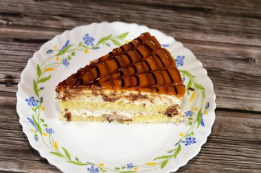 Üzerine karamel katmanı ve çikolata sosu katılmış kek katmanları arasında krem şanti, parti ve doğum günü kutlaması için üçgen şeklinde pasta.