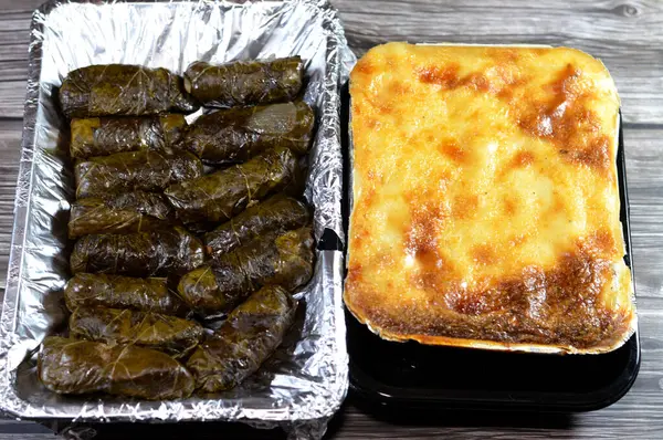 stock image The pasta with bechamel sauce and ground minced meat and ghee cooked in the oven, Bechamel Pasta Bake (Macarona Bechamel) and wrapped grape leaves stuffed Egyptian Mahshi and filled with white rice