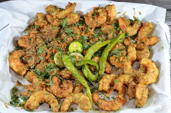 stock image Fried shrimps with parsley, fried green chili pepper and lemon, crunchy fried peeled shrimps seasoned with salt, pepper and spices, a shrimp is a crustacean form of shellfish belongs to the Caridea