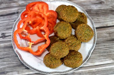 Renkli dolma biber dilimleri ve geleneksel Mısır kızarmış falafel topları, yeşil burger, bezelye ve fasulye, bol kızarmış toplar veya köfte şeklinde börek.