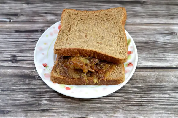 stock image whole wheat brown toast filled with Pressed amhaat dates with ghee, Egyptian amhaat dates fruit, fully mature, consumed in the soft the Khelal phase when the fruit is fully mature, Amhaat date fruit