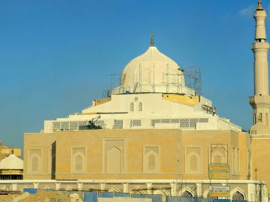 Kahire, Mısır, 21 Eylül 2024: Kubbe etrafında inşaat halindeki yeni bir cami, Mescid 'in yüksek minaresi, iskelesi ve Kahire şehrinde bir vinç bulunan yeni bir cami.