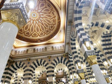 The interior of The Prophet's Mosque In Madinah or Al Masjid Al Nabawi, a major site of pilgrimage that falls under the purview of the Custodian of the Two Holy Mosques in the kingdom of Saudi Arabia clipart