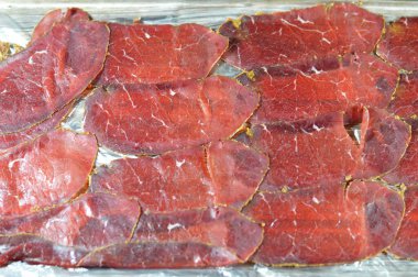 Biftek göğüs etinden yapılan ince pastırma dilimleri, çiğ et tuzlu, kısmen kurutulmuş, otlar ve baharatlarla tatlandırılmış, sonra Romanya 'dan gelen konserve sığır eti gibi tütsülenmiş ve buharlanmış.