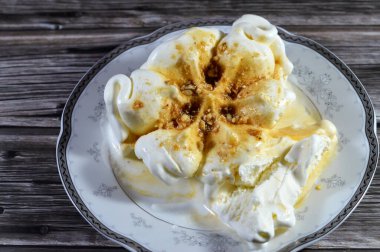 Karamel soslu zengin vanilyalı karamelli dondurma ve üzerine karamelli fındık parçaları, dondurulmuş ve servis edilmeye hazır, yaz zamanı ve tatil konsepti, ferahlatıcı ve eğlenceli, seçici odaklanma.