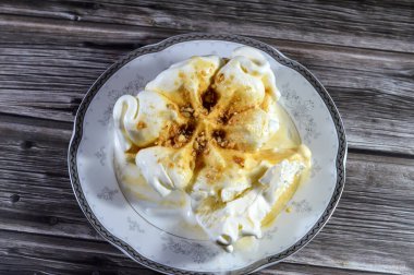 Karamel soslu zengin vanilyalı karamelli dondurma ve üzerine karamelli fındık parçaları, dondurulmuş ve servis edilmeye hazır, yaz zamanı ve tatil konsepti, ferahlatıcı ve eğlenceli, seçici odaklanma.