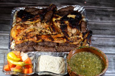 Egyptian food of Mulukhiyah, molokhia, molohiya or ewedu, beef Kofta kufta shish, minced meat charcoal grilled, chicken grilled and roasted on a charcoal grill, rice with vermicelli, Tahini, Pickles clipart